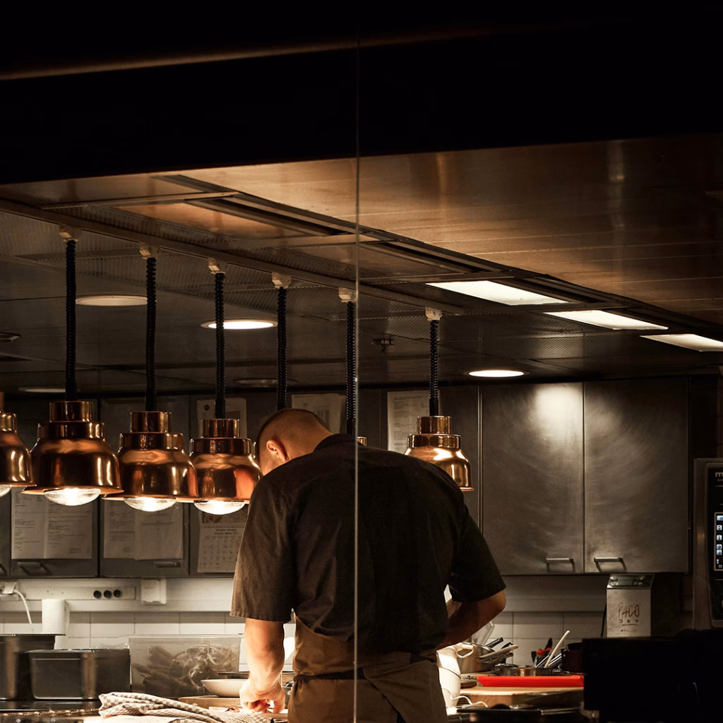 Koch in professioneller Restaurantküche mit moderner Beleuchtung – Energiekosten Gastronomie