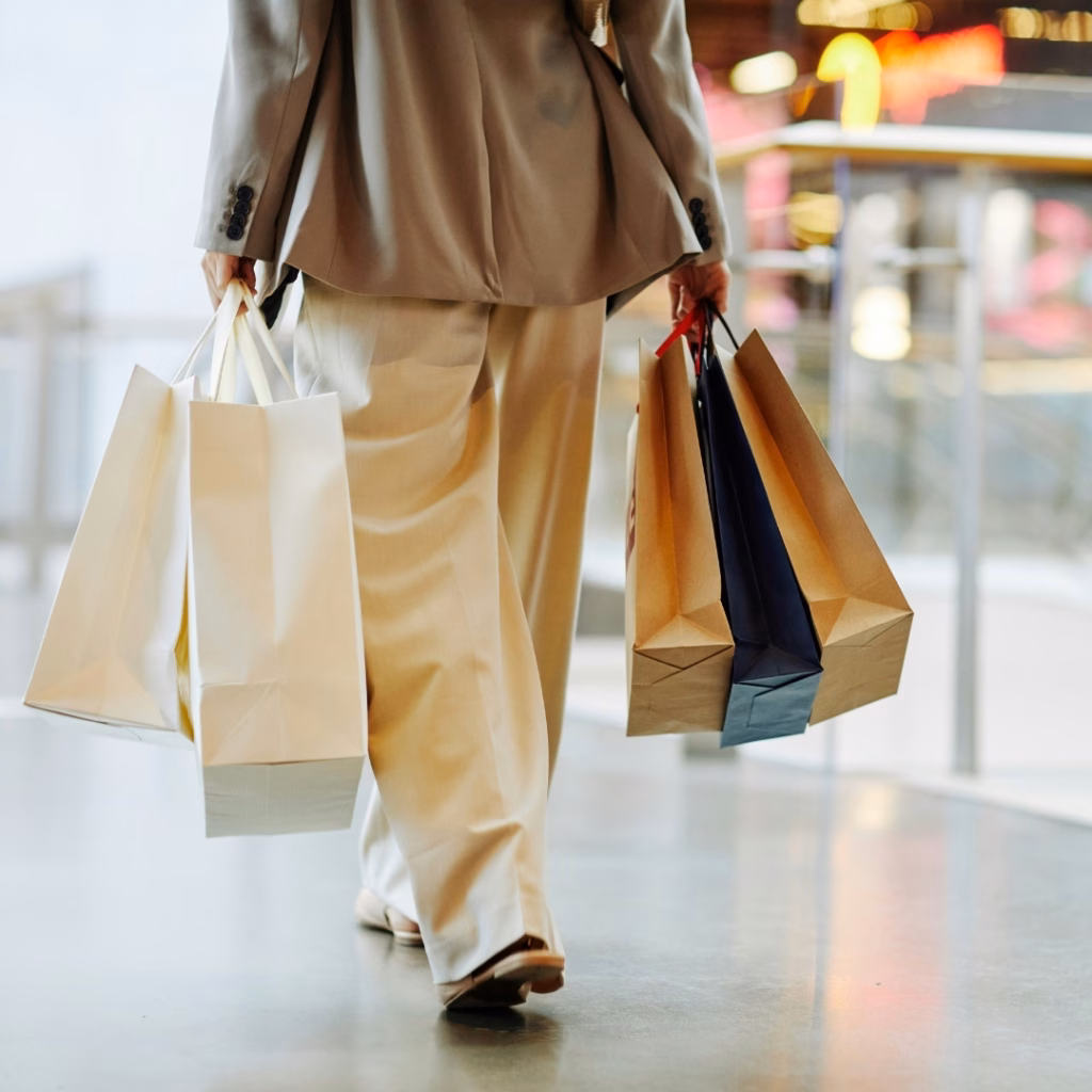 Kundin mit Einkaufstüten im Einkaufszentrum – steigende Energiekosten im Einzelhandel beeinflussen Betriebskosten